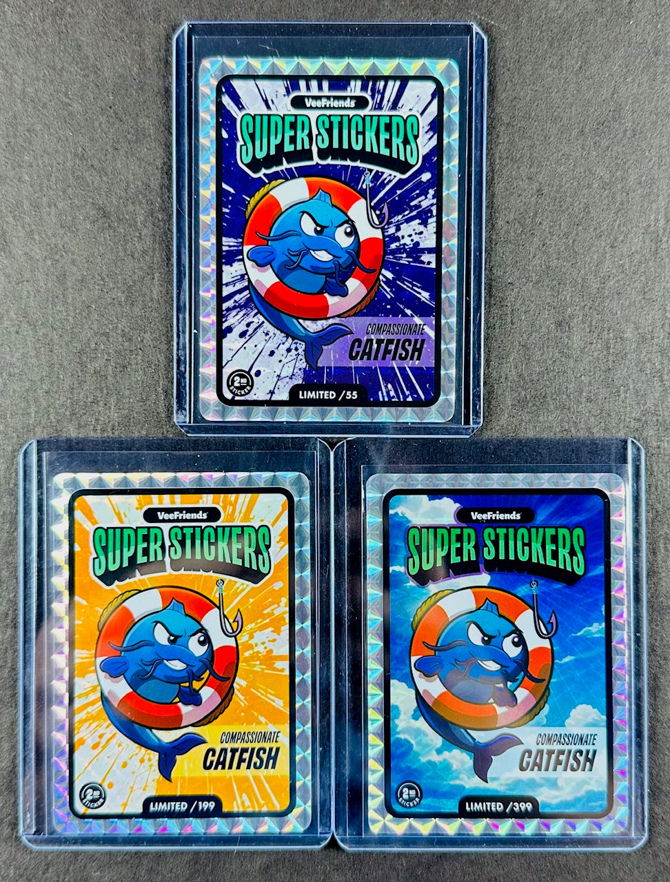 VeeFriends Super Stickers – Compassionate Catfish 3-Card Bundle – Purple Splash /55 + Orange Splash /199 + Manga Clouds /399
